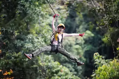 Girl smiling with arms and legs out while riding a zip line near Gatlinburg TN