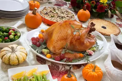 A delicious roast turkey and other Thanksgiving dishes on a table.