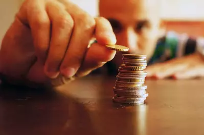 Man counting coins on the table to save money